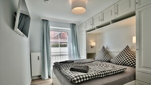 Camera da letto con un letto, tende, una finestra e armadi a muro.