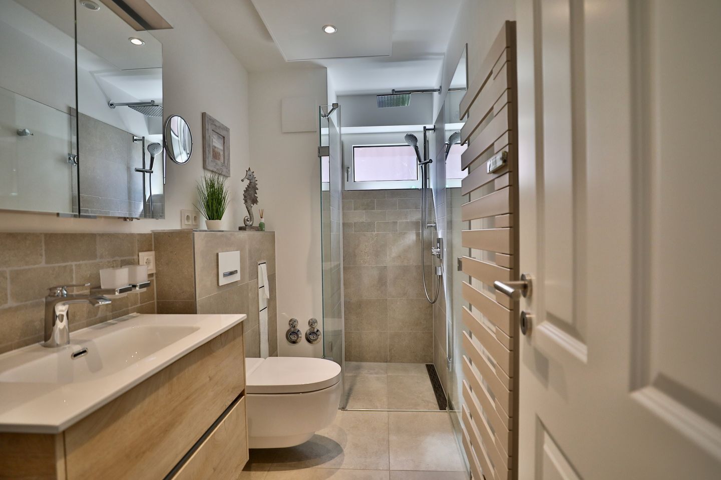 A modern bathroom with a shower, toilet, and sink.