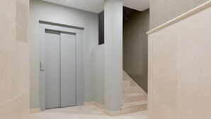 A hallway with a door, a staircase, and a textured wall. - Souvirón de Torres III (Málaga)