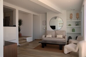 Ein modernes Wohnzimmer mit einer Couch, einem Couchtisch und einem großen Spiegel.