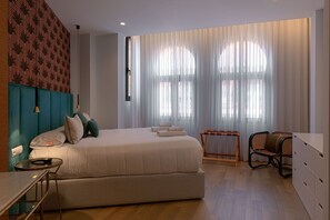 A modern hotel room with a bed, a desk, a chair, and a wardrobe. - Souvirón de Torres IV Duplex with Terrace (Málaga)