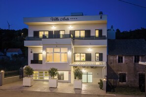 En toetages bygning med skiltet 'Villa Ante' og indkørsel til garage.