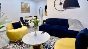 A modern living room with a sofa, armchairs, a coffee table, and a chandelier. - L Rina Apartment (Lekki)