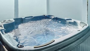 Uma banheira de hidromassagem com estrutura metálica, um ralo e uma etiqueta lateral.
