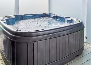 Een hottub met een rechthoekige vorm, een metalen rand en een watergevuld binnengedeelte.