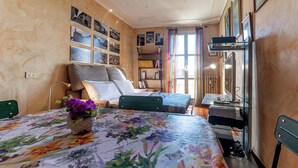 A bedroom with a bed, a sofa, a desk with a computer, a bookshelf, and a window with curtains. - D&R Apartment - Metro Re di Roma (Rome)