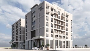 Un hotel de varios pisos con balcones, ventanas amplias y un diseño arquitectónico moderno.