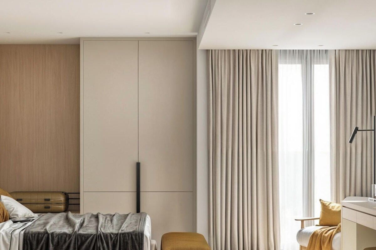 A modern bedroom with a bed, a desk, and a wardrobe.