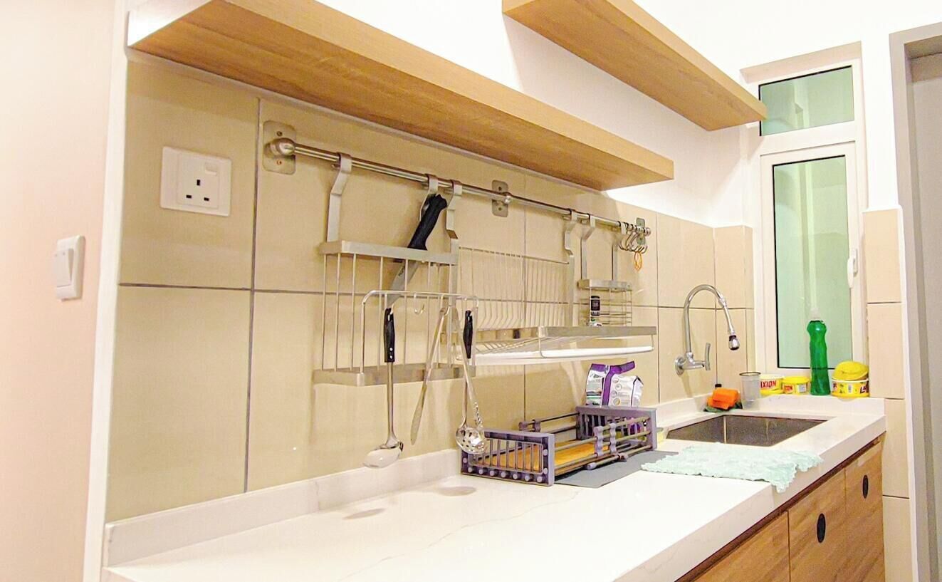 A kitchen with a built-in oven, a sink, and a window above the counter.