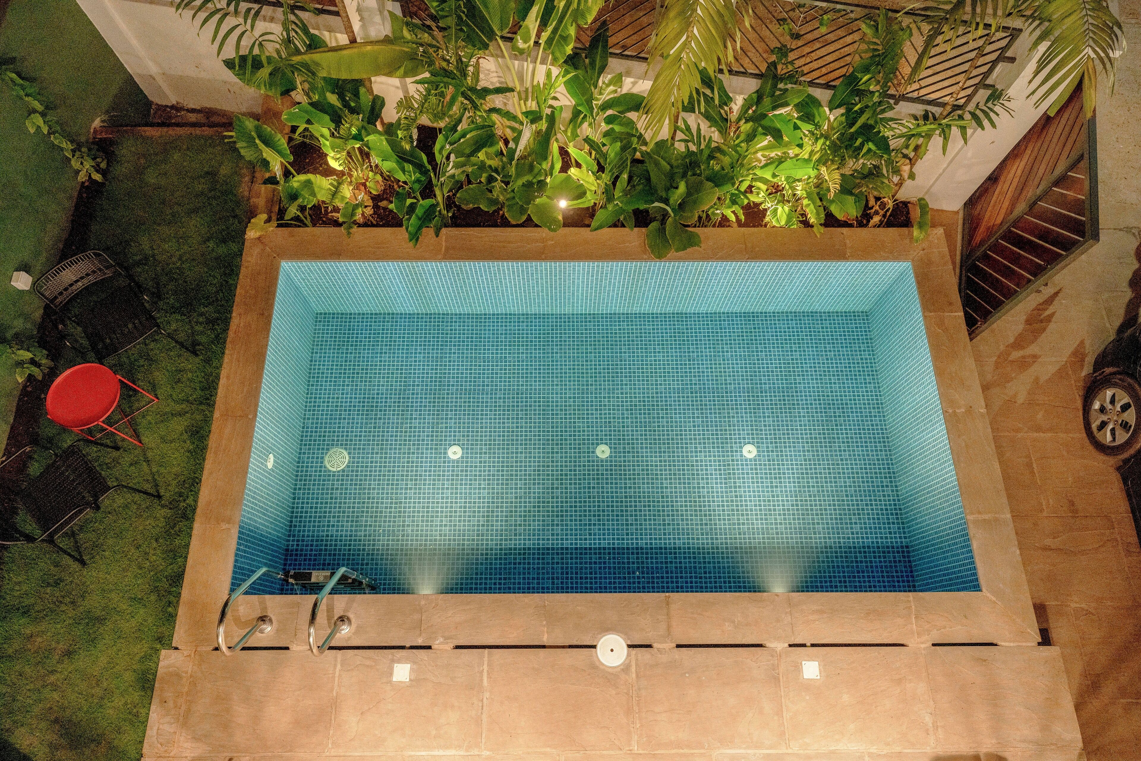 A rectangular pool with a tiled floor, surrounded by a stone deck.