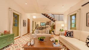 Ein Wohnzimmer mit einer Couch, einem Couchtisch und einer Treppe zu einer oberen Etage.