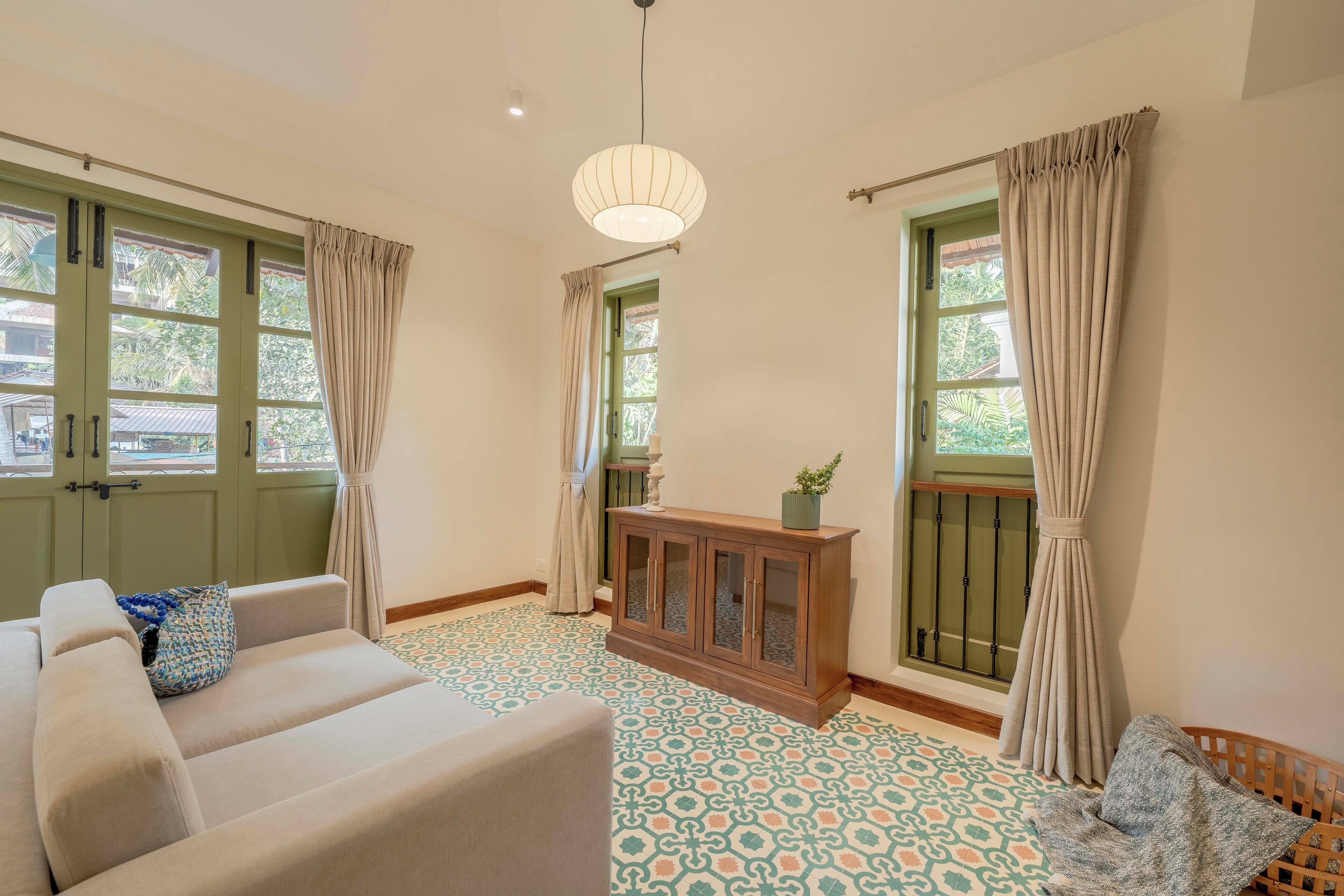 A room with a sofa, a cabinet, and patterned flooring.