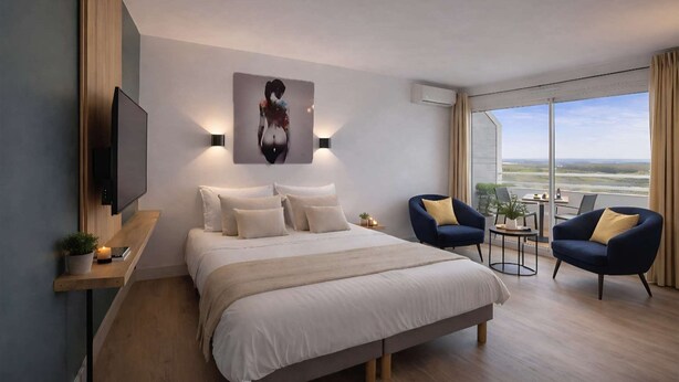 Camera d'albergo moderna con un letto grande, una televisione, un quadro e vista sul paesaggio.