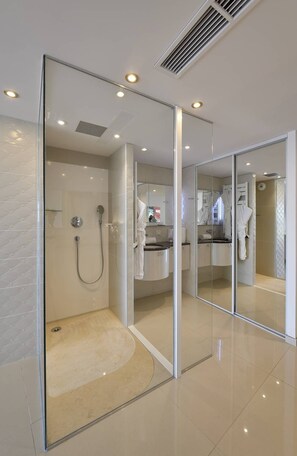 Ein modernes Badezimmer mit Duschkabine aus Glas, Waschtisch mit Spiegel und Toilette.