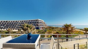 Ein Hotel mit Pool, Palmen und Meerblick.