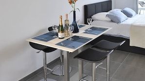 Ett modernt hotellrum med en matplats som inkluderar ett bord, stolar och en vas med blommor.