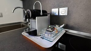 A coffee machine on a countertop with a glass container holding a coffee pod and a small item. - NAUTILIA  205 - Superior Luxe - Terrace - 2 people (AGDE)