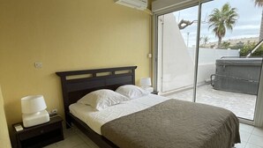 A bedroom with a bed, bedside lamps, a nightstand, a window, and a view of the outside. - BUBBLE Natura Beach - Apartement NB2 - Luxe - 6 people (AGDE)