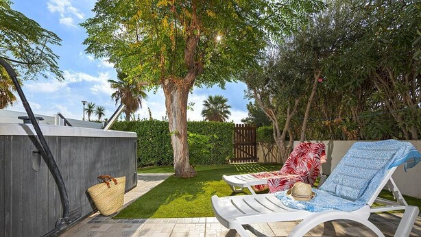 A patio with two sun loungers, a small shed, and a tree. - BUBBLE Natura Beach - Apartement NB2 - Luxe - 6 people (AGDE)
