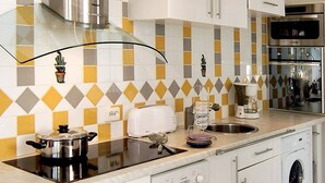 A modern kitchen with a stainless steel range hood, a dishwasher, a washing machine, and a coffee maker. - BUBBLE Natura Beach - Apartement NB2 - Luxe - 6 people (AGDE)