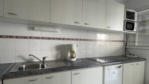 A kitchen with white cabinets, a stainless steel sink, a coffee maker, and a dishwasher. - Natura Beach - Apartment NB303 - 8 people (AGDE)