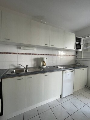 A kitchen with white cabinets, a stainless steel sink, a coffee maker, and a dishwasher. - Natura Beach - Apartment NB303 - 8 people (AGDE)