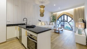 A modern kitchen with a central island, white cabinetry, and a large window with a view. - Souvirón de Torres (Malaga)