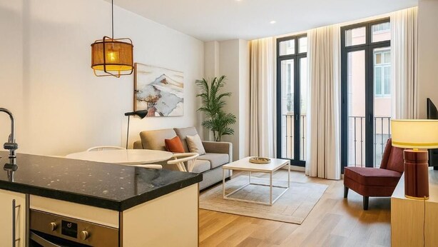 A modern living room with a sofa, coffee table, and a dining area. - Souvirón de Torres (Malaga)