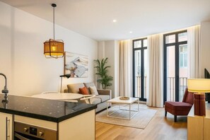 Un salon moderne avec un canapé, une table basse et un coin repas.