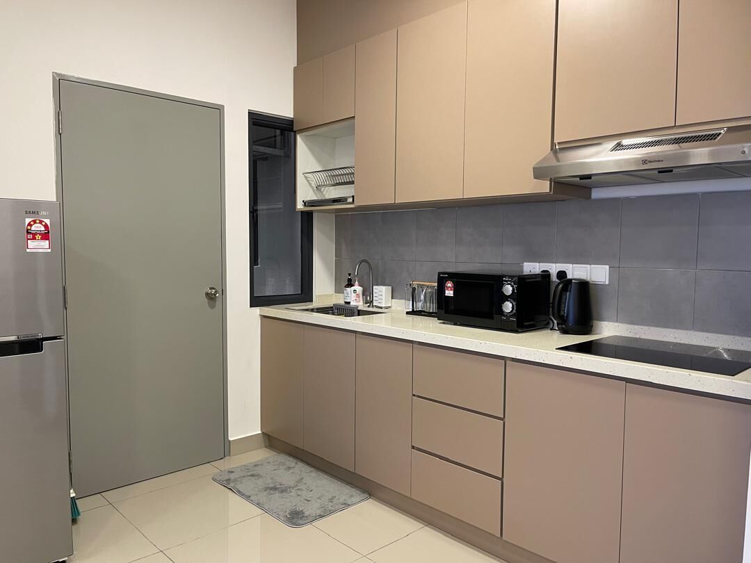 A kitchen with a microwave, sink, and stainless steel range hood.