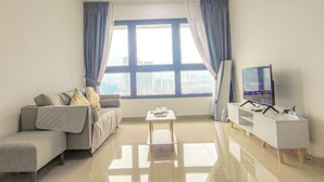 A modern living room with a sofa, a coffee table, a flat-screen TV, and a large window with curtains. - Massive KL View at M-Vertica by HCK (Kuala Lumpur)