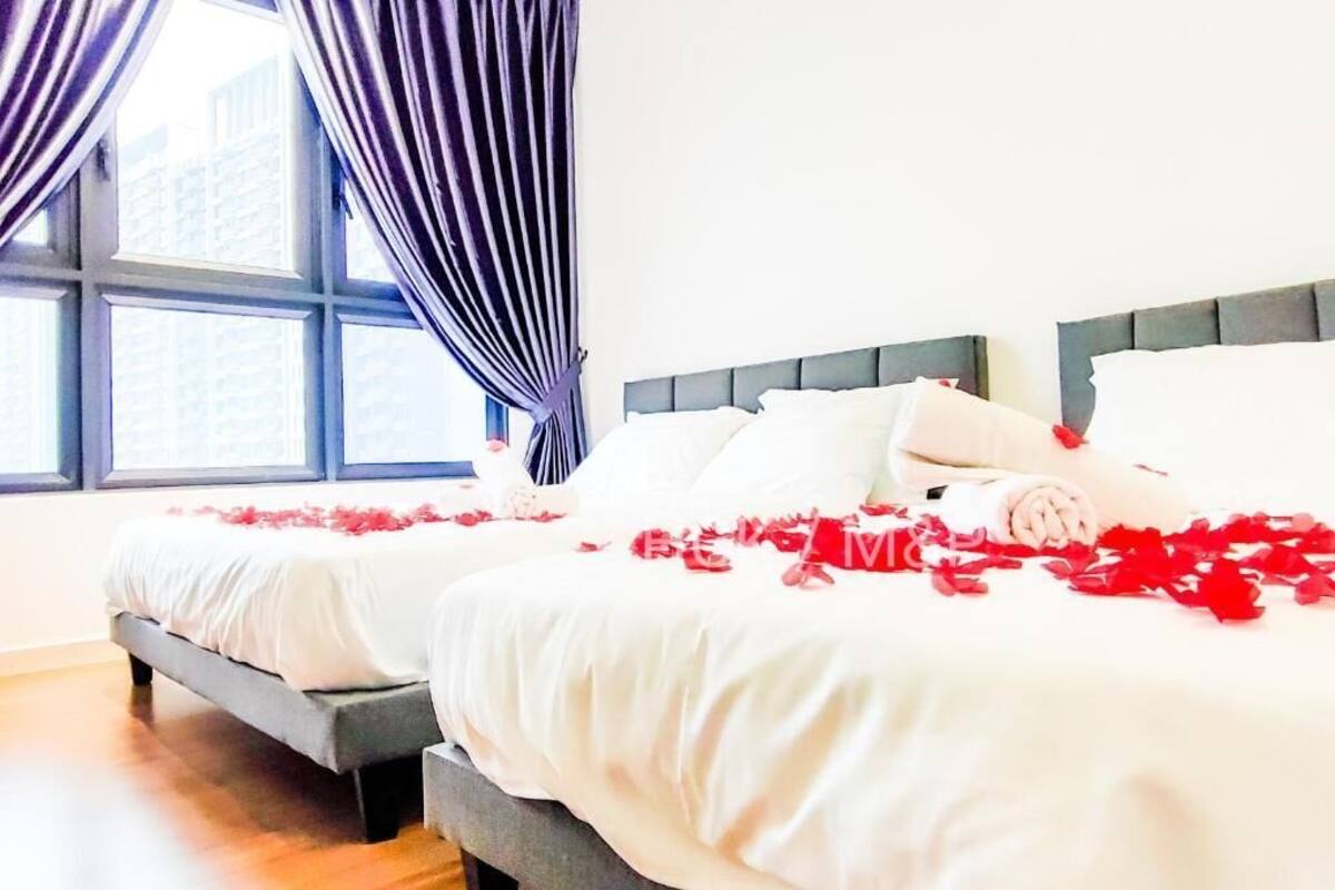 Ein Hotelzimmer mit zwei Betten, einem großen Fenster und Vorhängen.