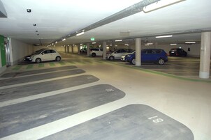 A multi-level underground parking garage with several cars parked.