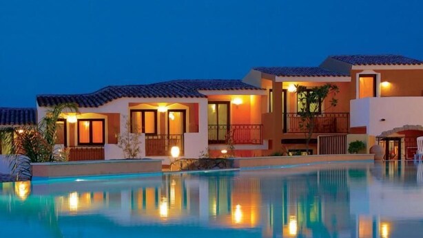 Un hôtel doté d’une piscine, de plusieurs bâtiments et d’un éclairage extérieur.