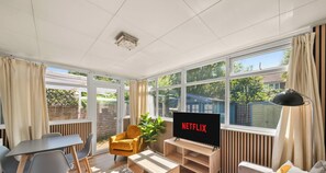 A modern living room with a TV, comfortable seating, and large windows. - 20%OFF - Modern 4BR Reading Home - Free Parking (Woodley)