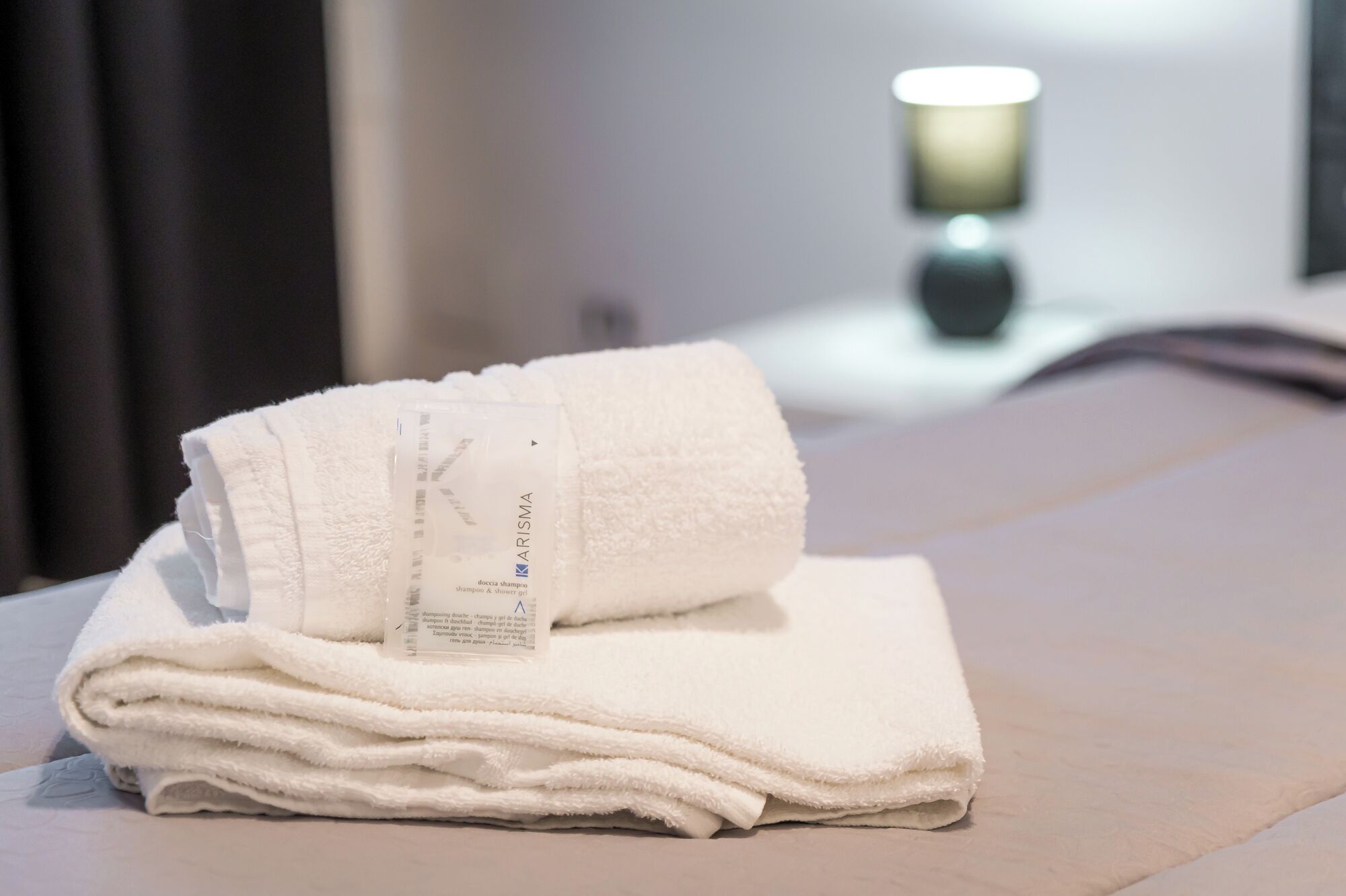 Ein ordentlich gefaltetes weißes Handtuch mit einem Etikett auf einem Tisch im Hotelzimmer.