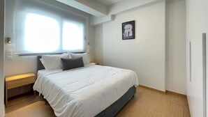 Una camera da letto con un letto, un comodino e una finestra.