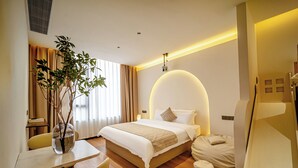 A hotel room with a bed, bedside table, chair, and a plant. - Jingdezhen Ruchu Hostel - Tao Xichuan  (Jingdezhen)