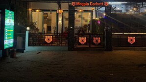 Restaurante Magpie Corbett com mesas ao ar livre e uma decoração de tigre.