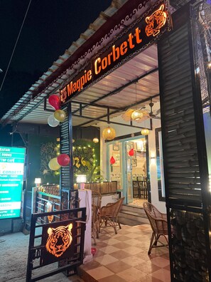 Un restaurante llamado Magpie Corbett con terraza, un logotipo de tigre y un cartel de menú.