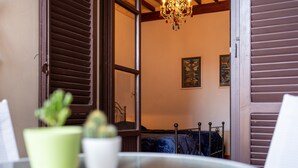A room with a bed, a table with a potted plant, and a chandelier.