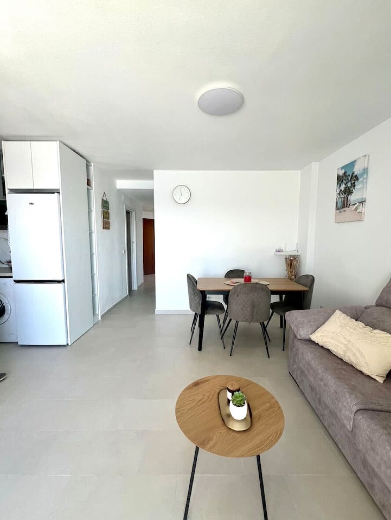 A modern kitchen with a built-in refrigerator and a dining area with a table and chairs.