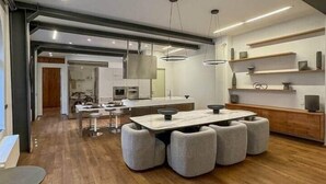 A modern kitchen with a central island, pendant lighting, and wooden flooring. - Loft @ Veratti by iCasamia .it (Varese)