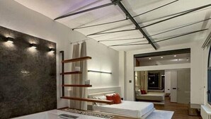 A modern bathroom with a large bathtub, wooden flooring, and a ceiling with exposed beams. - Loft @ Veratti by iCasamia .it (Varese)