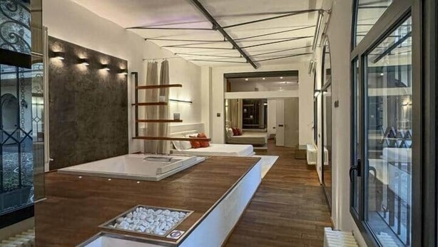 A modern interior with a central island, wooden flooring, and a view through large windows. - Loft @ Veratti by iCasamia .it (Varese)
