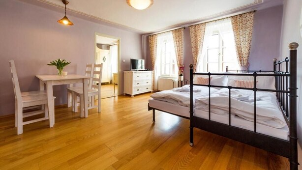 Ein Schlafzimmer mit Bett, Schreibtisch, Stuhl, Kommode und Fernseher.