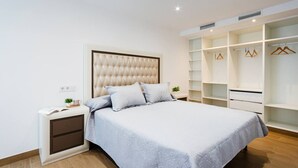 A bedroom with a bed, nightstand, and built-in wardrobe. - Esencia Marina la Najarra (Almuñécar)