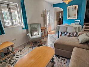 A living room with a sofa, armchair, dining table, and chairs. - Maison Almuñecar centre ! vue mer château montagne (Almuñécar)