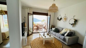 A living room with a sofa, coffee table, and a woven rug.