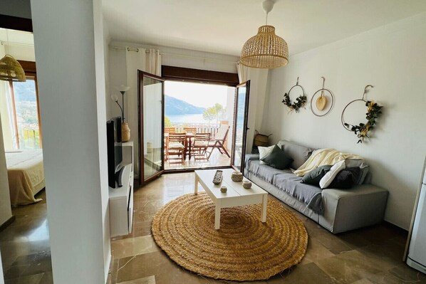 A living room with a sofa, coffee table, and a woven rug.